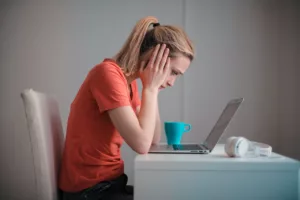a woman frustrated looking at her computer screen
