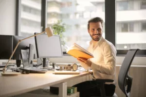 a smiling man working at his desk