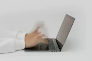 person rapidly typing on laptop computer