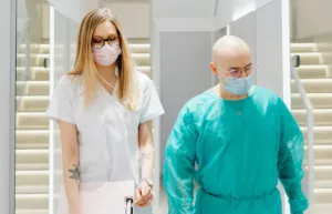 doctor and nurse walking down hall indoors masks