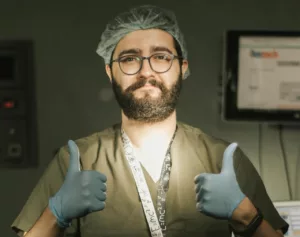 surgeon in scrubs giving two thumbs up