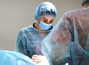 surgeon performing surgery in OR front over-patient view