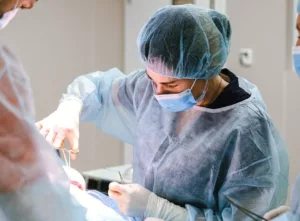 surgeon performing surgery in operating room with scissors 