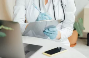 physician taking notes on clipboard