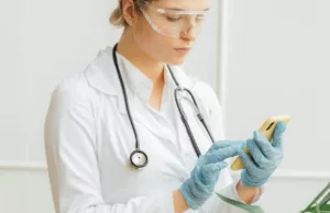physician taking notes on phone app