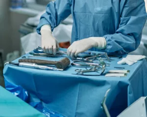 a surgical staff member setting up surgical tools according to preference cards for surgery